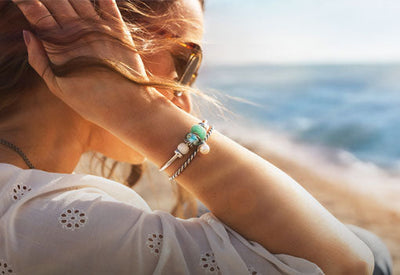Model with silver bangles and colourful summer beads on beach, Tides of Treasure summer collection 2025