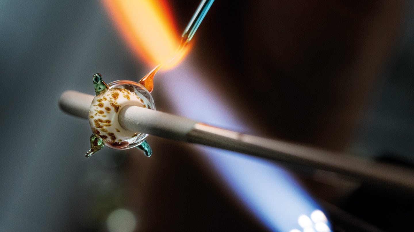 Trollbeads sand grains glass bead in the making in a red-hot flame.