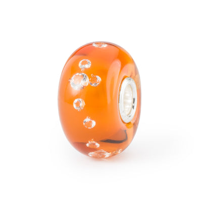 A murano glass bead from Trollbeads named Kiwi. It has orange and transparent glass with many small  air bubbles.