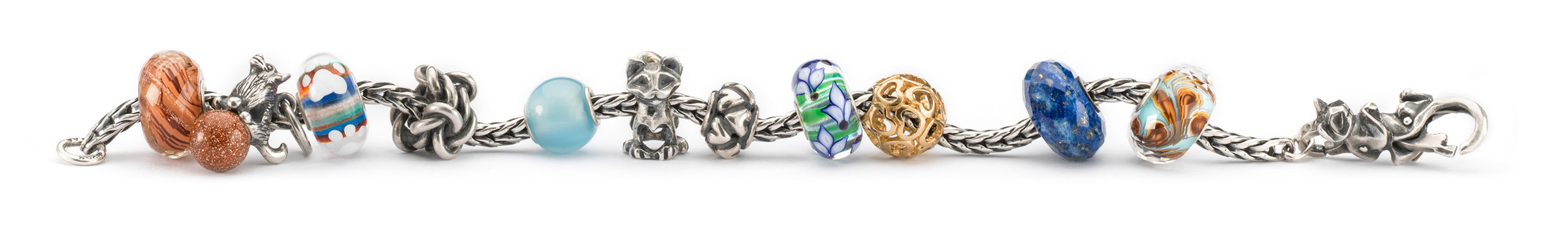 Trollbeads bracelet with a mix of beads in silver, gold and gemstones, one glass bead with a small paw print charm, and beads with cats and a dog representing the bond and affection between pets and their owners.