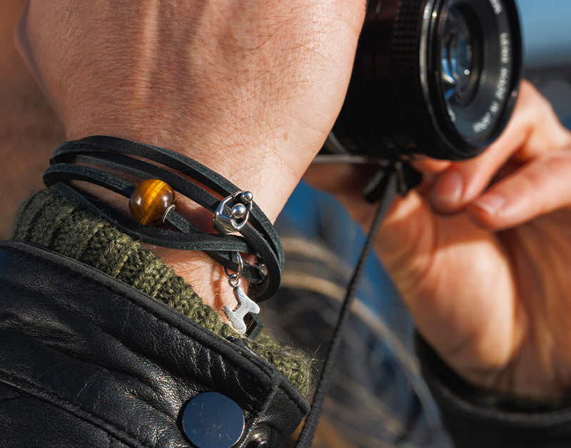 Trollbeads double leather bracelet with a with two beads and a tassel on a man taking pictures with a camera